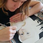 Teen girl drawing a realistic portrait of her younger sister using colored pencils